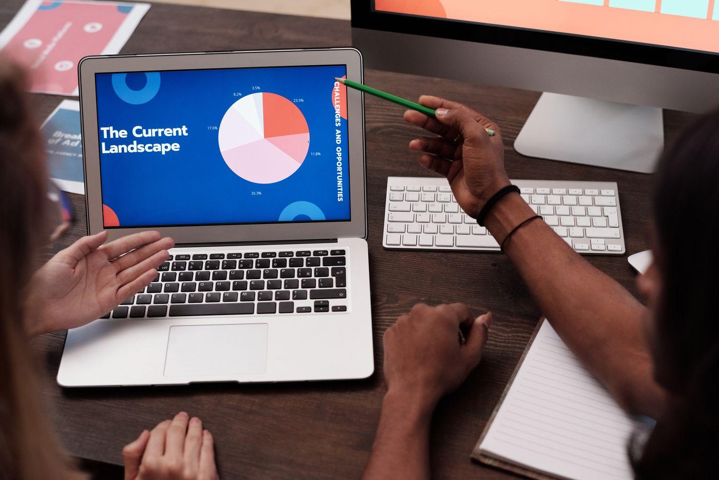 Team members discussing a graph on a laptop, illustrating the review of marketing data rather than an actual campaign result.